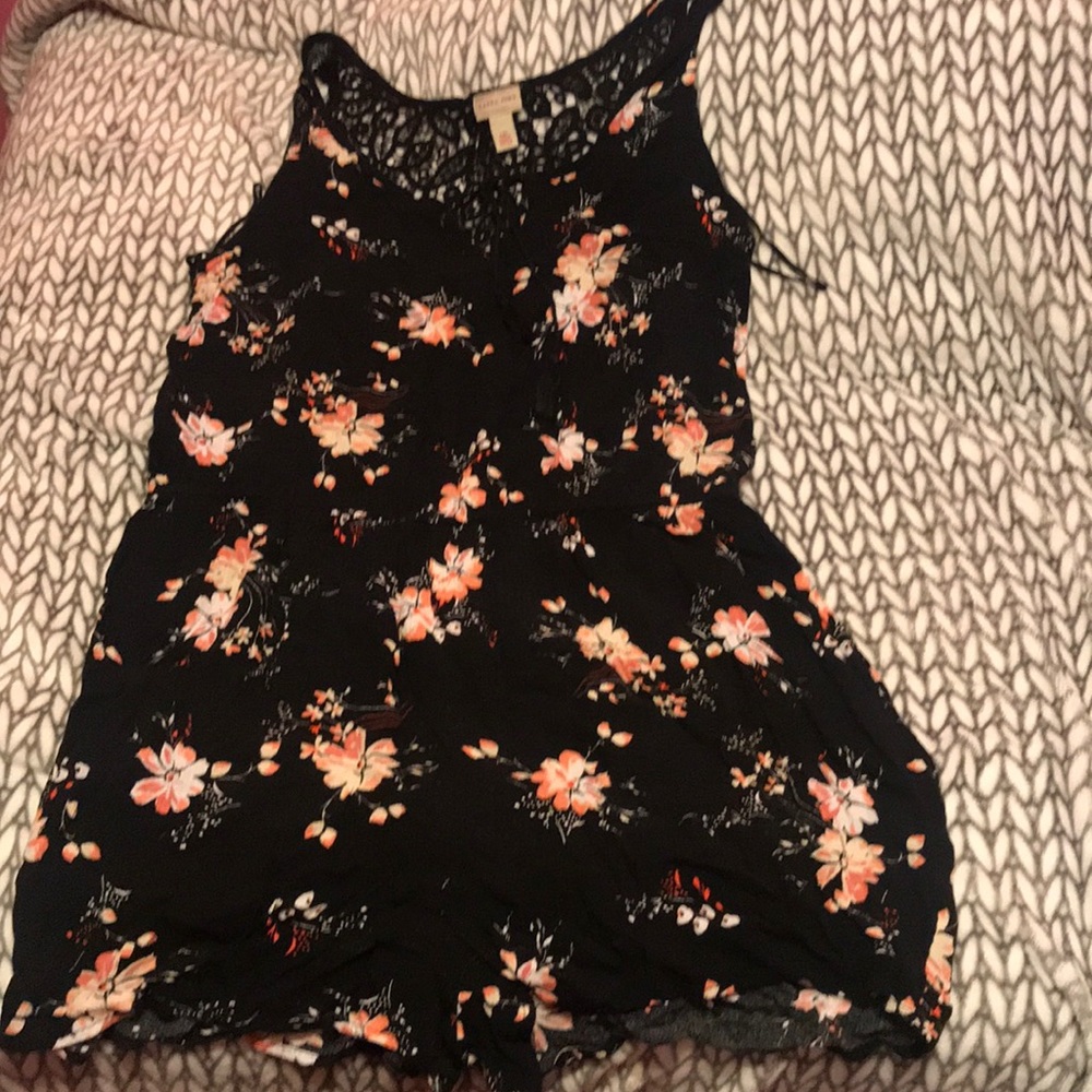 Black romper with pink flowers around.